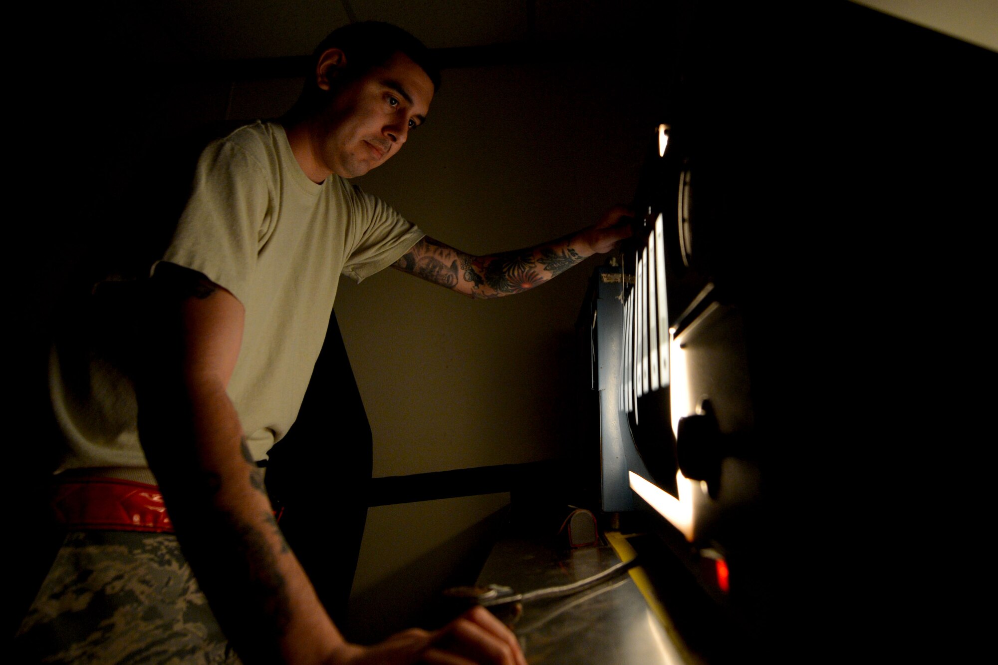 U.S. Air Force Staff Sgt. Anthony Arguello, 20th Equipment Maintenance Squadron non-destructive inspection craftsman, views developed film in the darkroom at Shaw Air Force Base, S.C., March 8, 2017. Arguello utilized a film processor to develop images of a piece of equipment to spot damage not visible to the naked-eye. (U.S. Air Force photo by Airman 1st Class Christopher Maldonado)