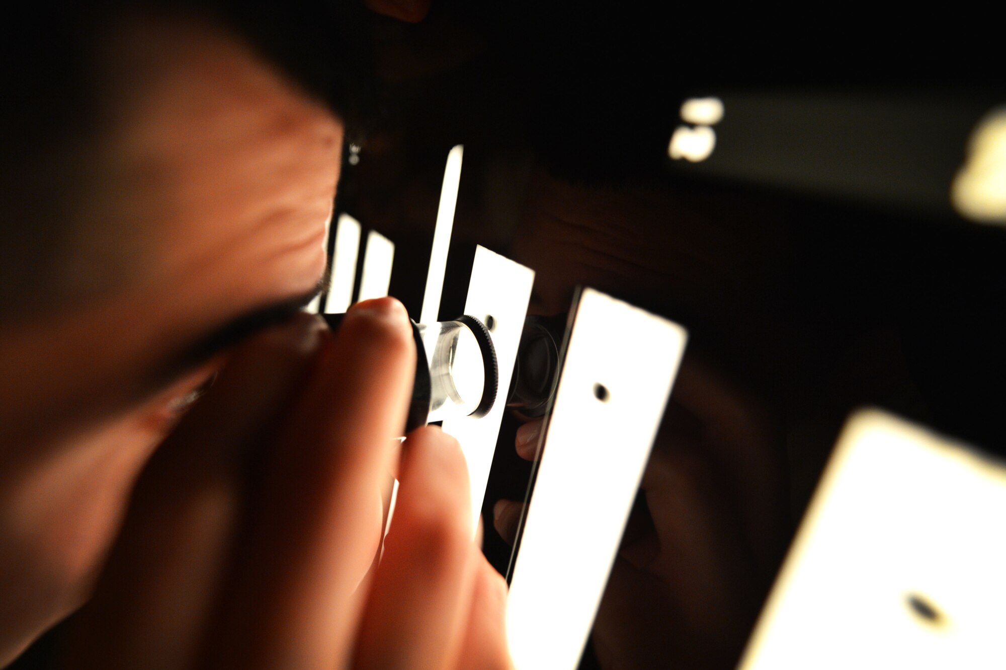 U.S. Air Force Staff Sgt. Anthony Arguello, 20th Equipment Maintenance Squadron non-destructive inspection (NDI) craftsman, uses a film magnifier to inspect x-ray film in the darkroom at Shaw Air Force Base, S.C., March 7, 2017. After the film has been developed, Airmen assigned to the NDI flight inspect the x-rays and report any damage to the maintenance agencies that requested the testing. (U.S. Air Force photo by Airman 1st Class Christopher Maldonado)