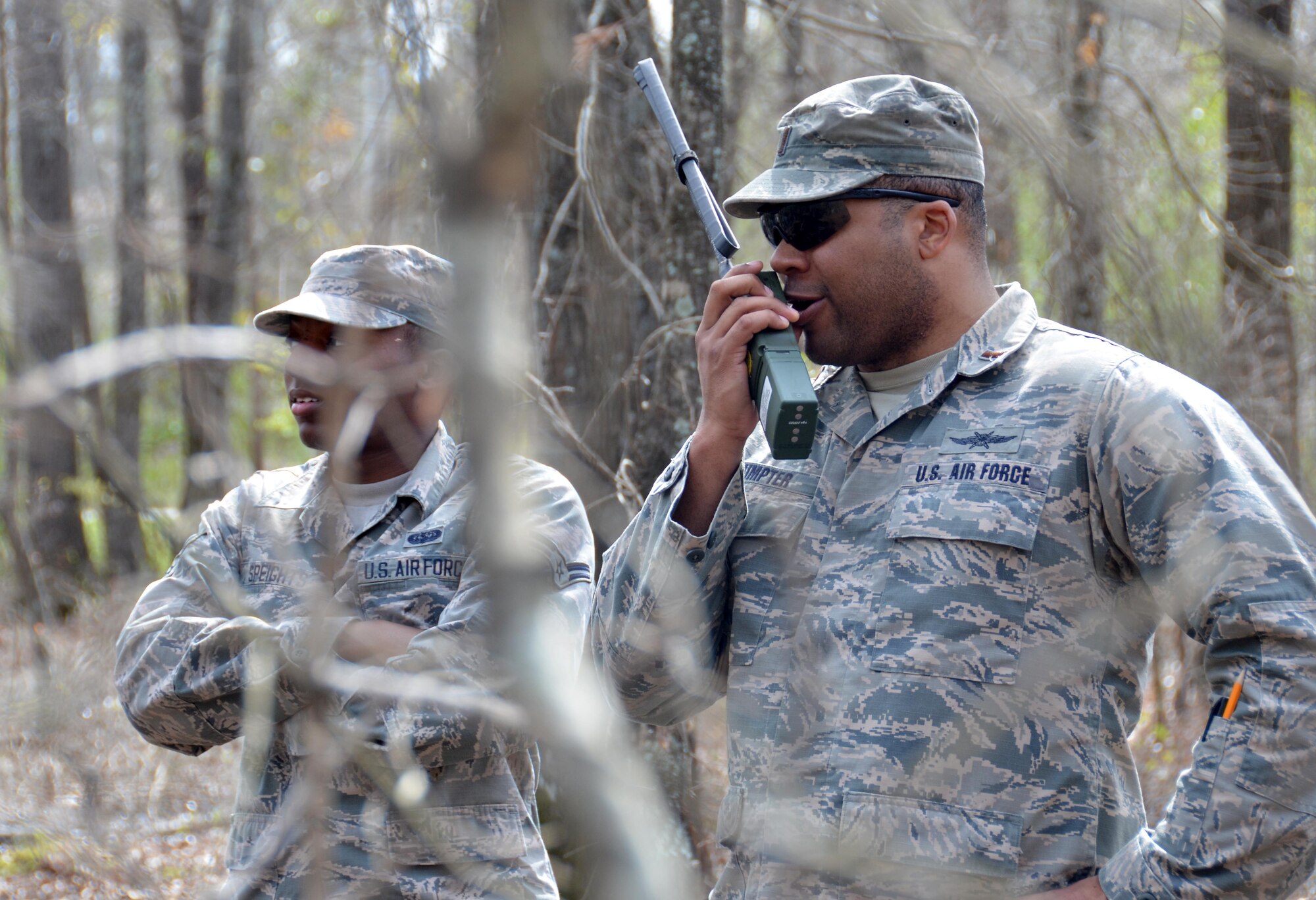 Second Lieutenant Steven Sumpter, 729th Air Control Squadron, communicates with the 5th Combat Communications Group while Airman 1st Class Tyzhe Speights, 51st Combat Communication Squadron, scans the area for a marker during a land navigation exercise on Robins Air Force Base, Ga., March 2, 2017. The 5th CCG provides a two-week course for a maximum of 34 students and cover a variety of topics such as land navigation, improvised explosive device detection, and much more. (U.S. Air Force photo by Tech. Sgt. Kelly Goonan/released)
