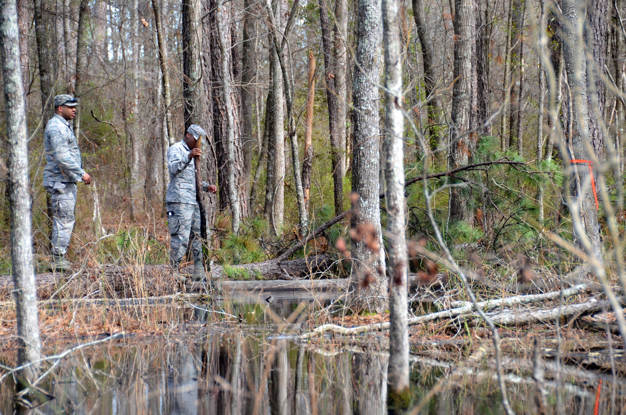 Second Lt. Steven Sumpter, 729th Air Control Squadron, and Airman 1st Class Tyzhe Speights, 51st Combat Communication Squadron, trek through a flooded area to get their designated marker during a land navigation exercise at Robins Air Force Base, Ga., March 2, 2017. The 5th Combat Communications Group provides a two-week course for a maximum of 34 students and covers a variety of topics like land navigation, improvised explosive device detection and much more. (U.S. Air Force photo by Tech. Sgt. Kelly Goonan/released)