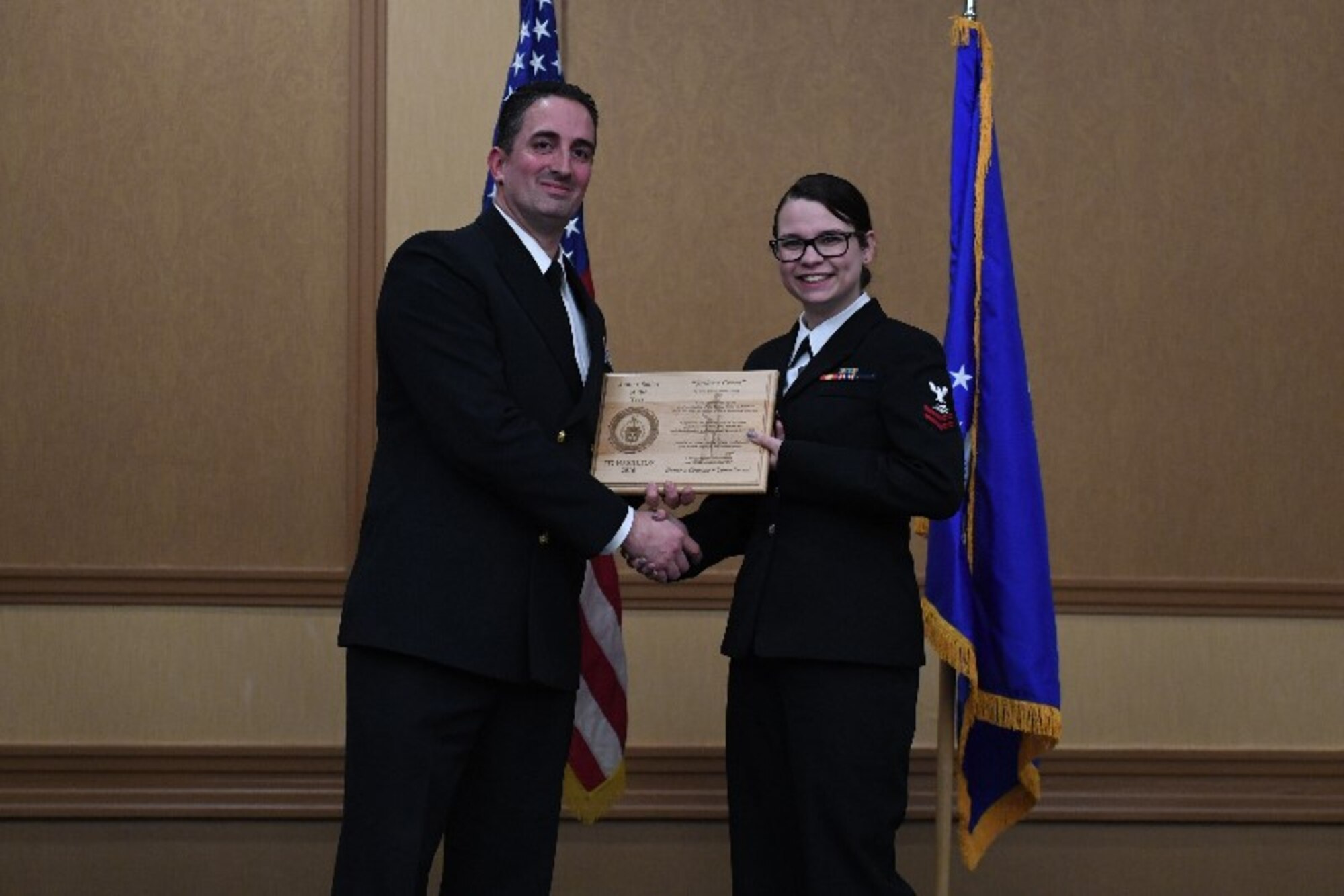 Petty Officer 2nd Class Samantha Hamilton, funeral honors department coordinator with the Naval Operational Center Pittsburgh, receives and award from Chief Christopher Degothseir, command chief  of NOSC Pittsburgh, at the 911th Airlift Wing Awards Banquet, Coraopolis, Pennsylvania, March 4, 2017. This marked the first year members of NOSC Pittsburgh were recognized alongside members of the 911th AW.