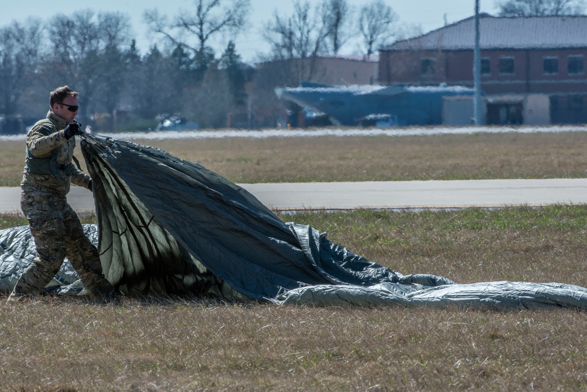Tech. Sgt. Kyle Oler, 375th Operations Support Squadron's Survival, Evasion, Resistance, and Escape non commissioned officer in charge, gathers his parachute after performing a static jump on March 2, 2017 at Scott AFB, Illinois. Scott AFB hosted this jump to streamline its capabilities and jump program while offering jumpers an opportunity to get required jumps accomplished as they face weather challenges elsewhere. The 375th OSS created the drop zone to increase the readiness of units in and around Scott AFB and for use by flying or ground units with an interest and the requirements. (U.S. Air Force photos/Senior Airman Tristin English)