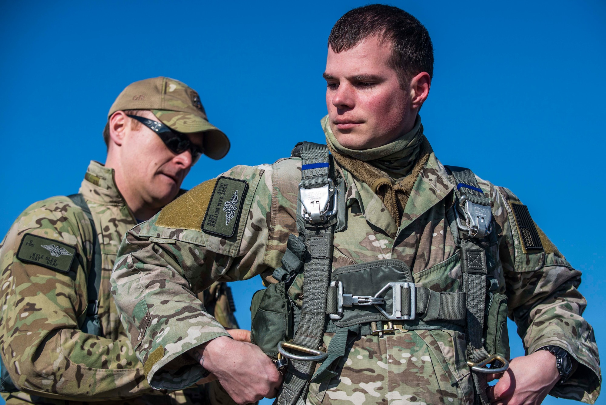 Tech. Sgt. Kyle Oler, 375th Operations Support Squadron's Survival, Evasion, Resistance, and Escape non commissioned officer in charge, helps Staff Sgt. Sam Neitzer, 375th OSS SERE specialist prepare his gear before a static jump on March 2, 2017 at Scott AFB, Illinois. Scott AFB hosted this jump to streamline its capabilities and jump program while offering jumpers an opportunity to get required jumps accomplished as they face weather challenges elsewhere. The 375th OSS created the drop zone to increase the readiness of units in and around Scott AFB and for use by flying or ground units with an interest and the requirements. (U.S. Air Force photos/Senior Airman Tristin English)