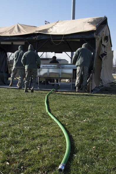 Food service Airmen from the 512th Memorial Affairs Squadron secure a tent while competing for the 2017 John L. Hennessy Award at Dover Air Force Base, Del., March 3, 2017. The Hennessy Award recognizes excellence in foodservices across multiple military branches. (U.S. Air Force photo / Renee M. Jackson)