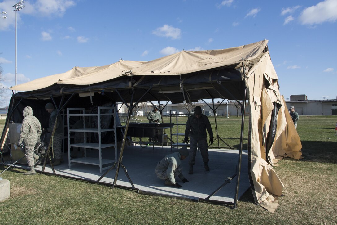 Food service Airmen from the 512th Memorial Affairs Squadron secure a tent while competing for the 2017 John L. Hennessy Award at Dover Air Force Base, Del., March 3, 2017. The Hennessy Award recognizes excellence in foodservices across multiple military branches. (U.S. Air Force photo / Renee M. Jackson)