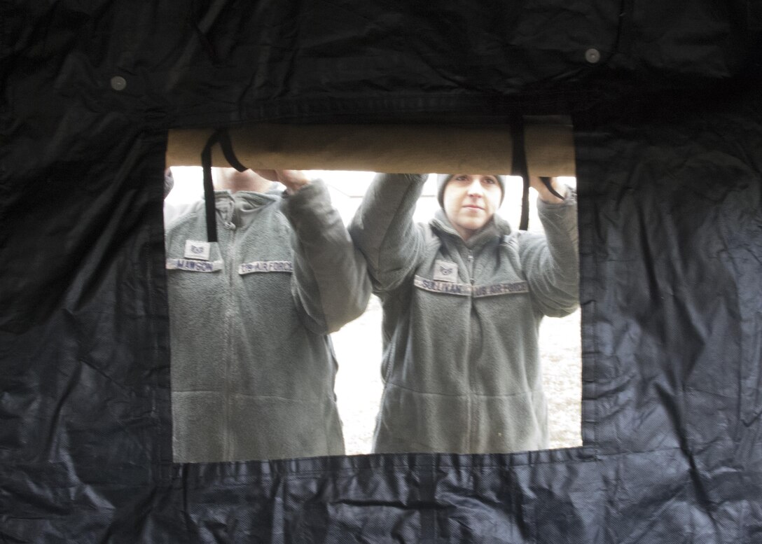 Tech. Sgt. Thomas Mawson and Staff Sgt. Stacy Sullivan, both food service specialist, 512th Memorial Affairs Squadron, secure a tent window while competing for the 2017 John L. Hennessy Award at Dover Air Force Base, Del., March 3, 2017. The Hennessy Award recognizes excellence in foodservices across multiple military branches. (U.S. Air Force photo / Renee M. Jackson)