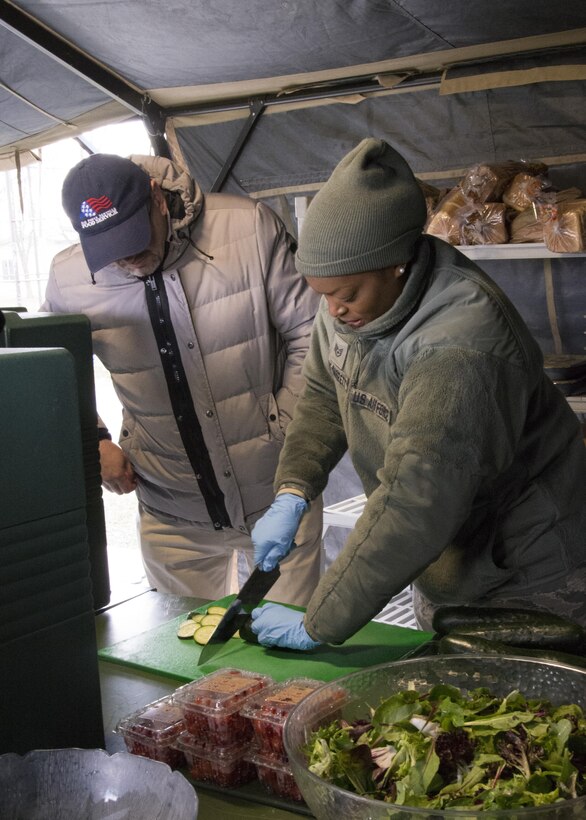 David Richmond, representative with the National Restaurant Association, watches Staff Sgt. Mercedes McCoy-Garrett, food services specialist, 512th Memorial Affairs Squadron, chop a zucchini after teaching her proper cutting techniques while competing for the 2017 John L. Hennessy Award at Dover Air Force Base, Del., March 3, 2017. The Hennessy Award recognizes excellence in foodservices across multiple military branches. (U.S. Air Force photo / Renee M. Jackson)