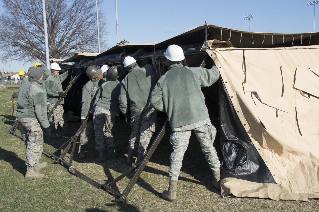 Food service Airmen from the 512th Memorial Affairs Squadron secure a tent while competing for the 2017 John L. Hennessy Award at Dover Air Force Base, Del., March 3, 2017. The Hennessy Award recognizes excellence in foodservices across multiple military branches. (U.S. Air Force photo / Renee M. Jackson)