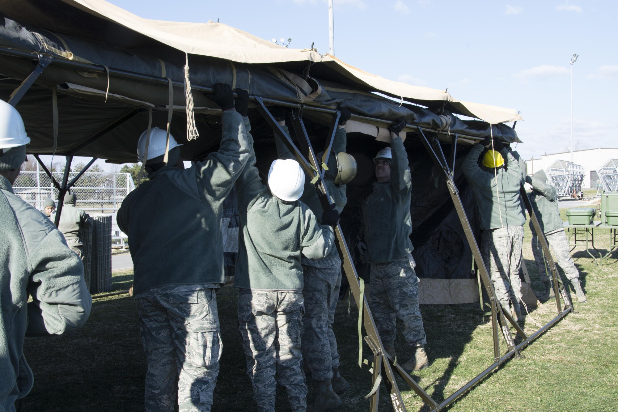 Food service Airmen from the 512th Memorial Affairs Squadron secure a tent while competing for the 2017 John L. Hennessy Award at Dover Air Force Base, Del., March 3, 2017. The Hennessy Award recognizes excellence in foodservices across multiple military branches. (U.S. Air Force photo / Renee M. Jackson)