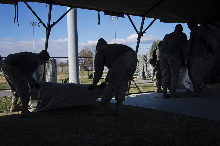 Food service Airmen from the 512th Memorial Affairs Squadron secure a tent while competing for the 2017 John L. Hennessy Award at Dover Air Force Base, Del., March 3, 2017. The Hennessy Award recognizes excellence in foodservices across multiple military branches. (U.S. Air Force photo / Renee M. Jackson)