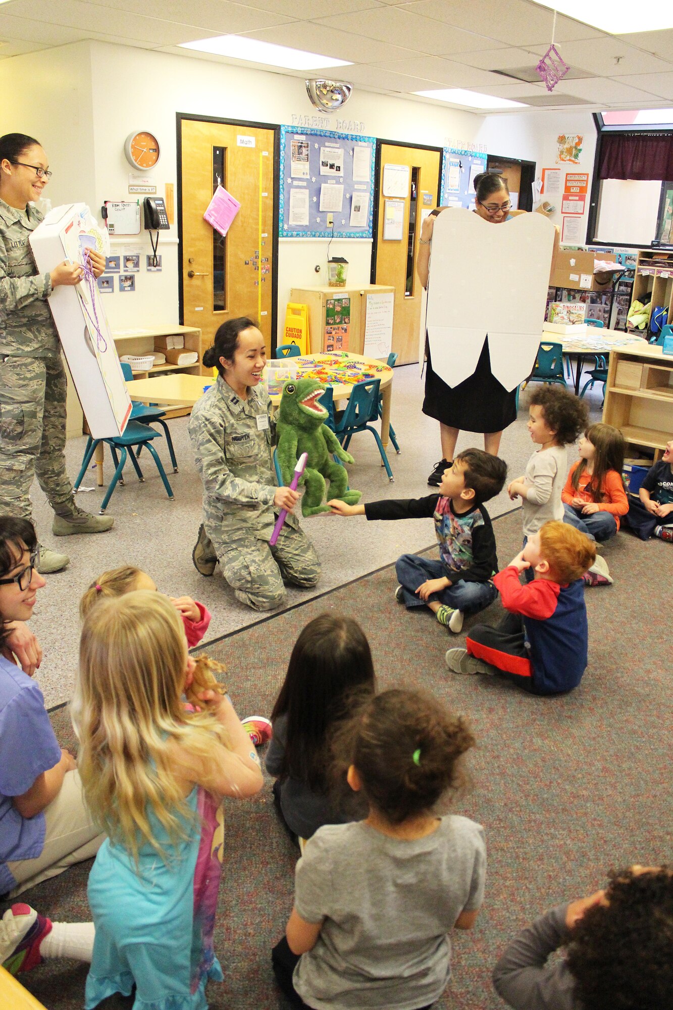 General dentist, Capt. Josephine Nguyen, 412th Aerospace Medicine Squadron (center), talks to children about healthy dental habits at the Child Development Center Feb. 24. She was assisted by Airman 1st Class Corrina Little, 412th AMDS dental assistant (left). (Courtesy photo)