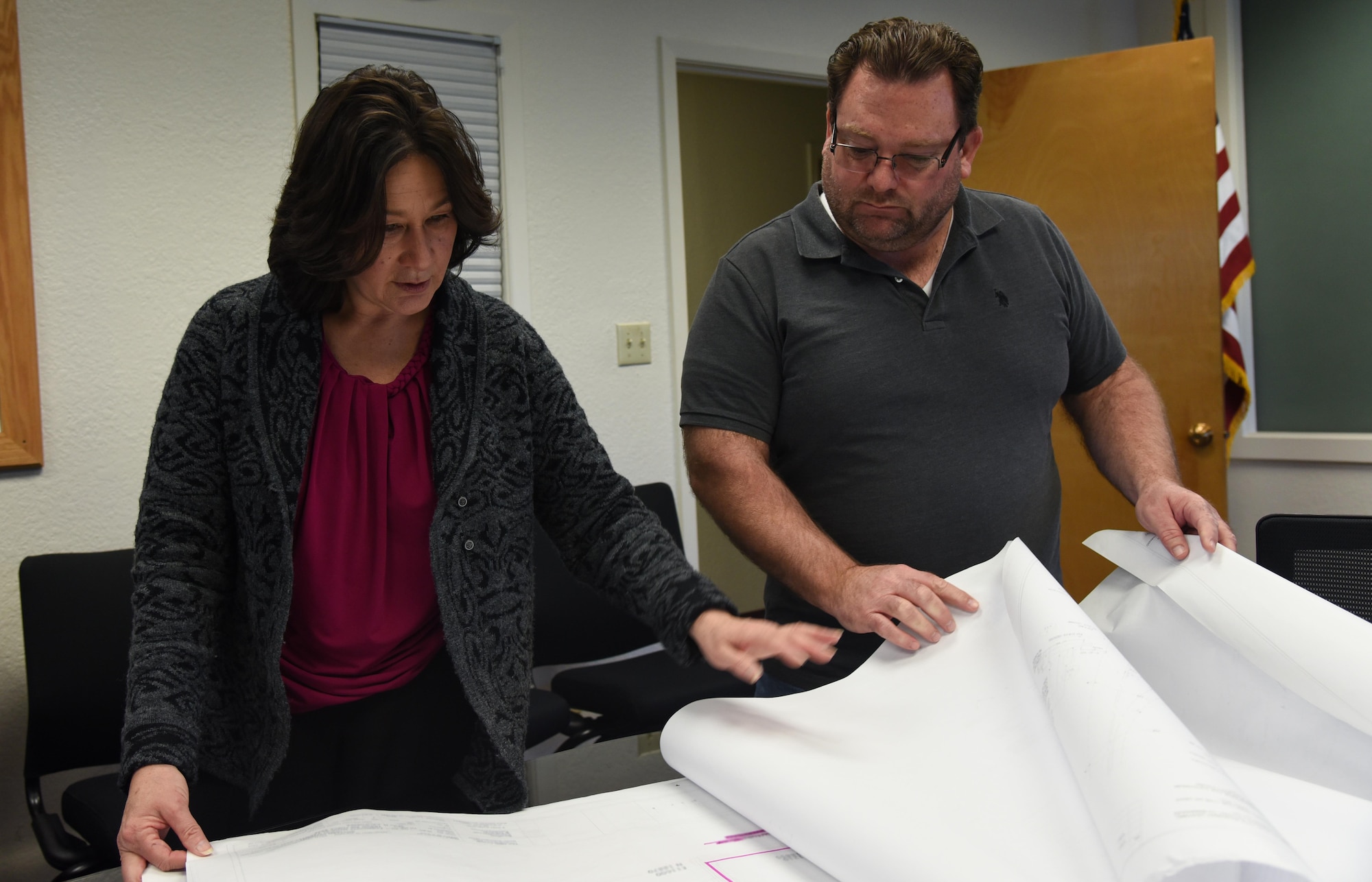 Michele Cardenas, 60th Civil Engineer Squadron operation flight deputy, and Mike West, 60th CES facility systems superintendent, review a print of the David Grant USAF Medical Center at Travis Air Force Base, Calif., March 2, 2017. Cardenas started working in the 60th CES during an initiative to hire women into craftsmen positions. (U.S. Air Force photo by Senior Airman Sam Salopek) (This image was blurred for security purposes) 