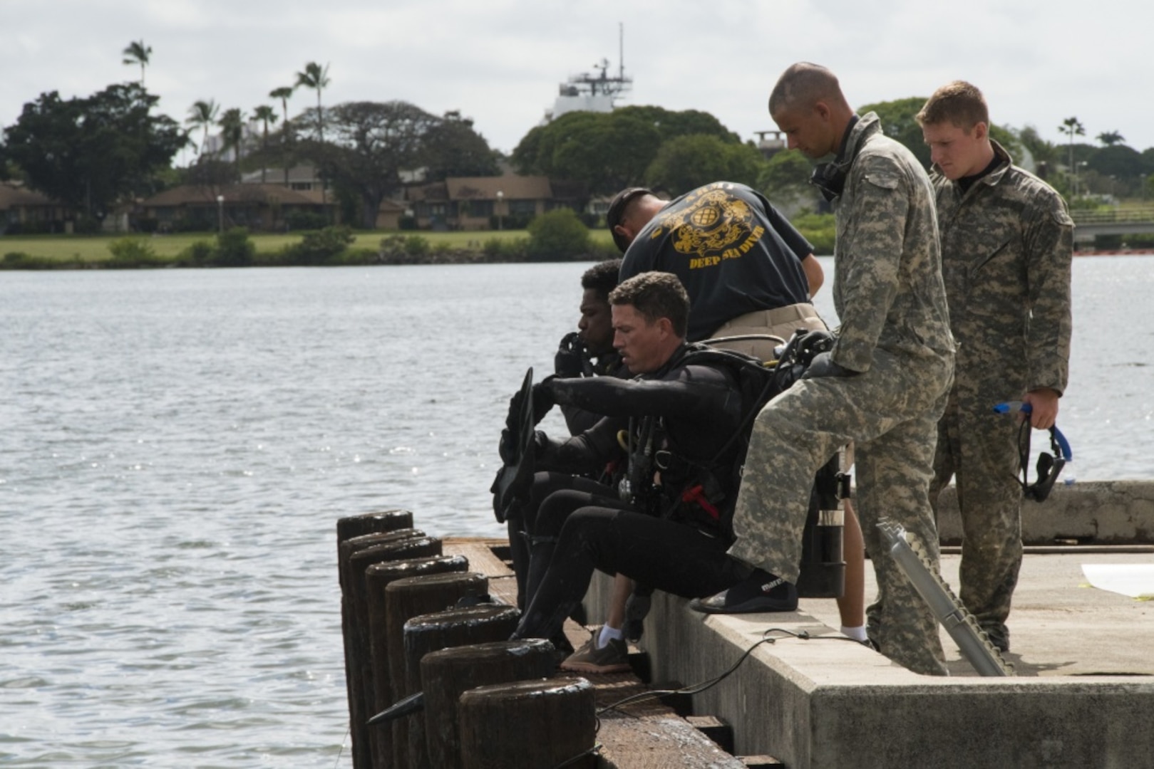 Army divers assigned to 7th Dive Detachment, 84th Engineer Battalion, prepare to demonstrate repair techniques on pier support pilings, March 3, 2017.  