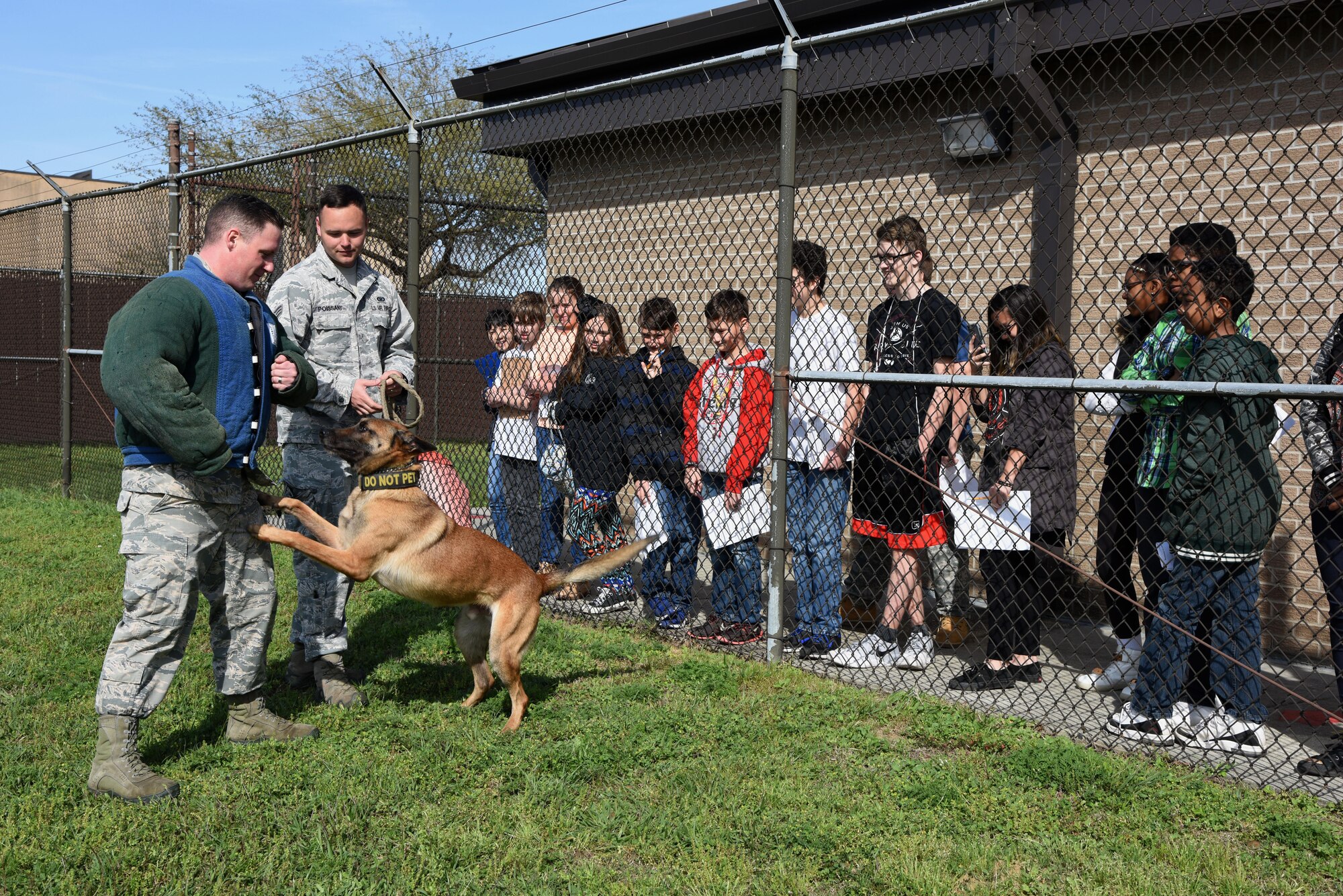 Senior Airmen Timothy Poissant, and Douglas Sullivan, 81st Security Forces Squadron military working dog handlers, and Zeno, 81st SFS military working dog, stage a scenario for school-aged children at the 81st SFS canine facility during Biloxi Career Exploration Day March 2, 2017, on Keesler Air Force Base, Miss. The children also toured the 334th Training Squadron air traffic control school, 335th TRS weather facility and the Keesler Fire Department. (U.S. Air Force photo by Kemberly Groue)