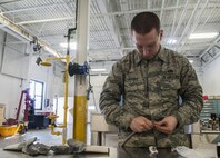 Senior Airman Daniel Moore, 5th Maintenance Squadron hydraulics journeyman, inserts a sleeve into a teflon hose at Minot Air Force Base, N.D., Feb. 23, 2017. Aircraft hydraulic systems maintainers are responsible for ensuring aircraft hydraulic and pneumatic systems work properly. (U.S. Air Force photo/Airman 1st Class Jonathan McElderry)