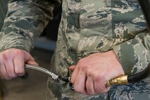 A 5th Maintenance Squadron pneudraulics department Airman removes excess liquid from a teflon hose at Minot Air Force Base, N.D., Feb. 23, 2017. Pneudraulics maintainers also ensure each hydraulic hose is completely dry to ensure its serviceability. (U.S. Air Force photo/Airman 1st Class Jonathan McElderry)