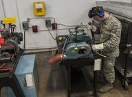 Senior Airman Daniel Moore, 5th Maintenance Squadron hydraulics journeyman, cuts a teflon hose at Minot Air Force Base, N.D., Feb. 23, 2017. Pneudraulics maintainers are responsible for maintaining all fluid, air or gas-pressured devices on the B-52H Stratofortress. (U.S. Air Force photo/Airman 1st Class Jonathan McElderry)