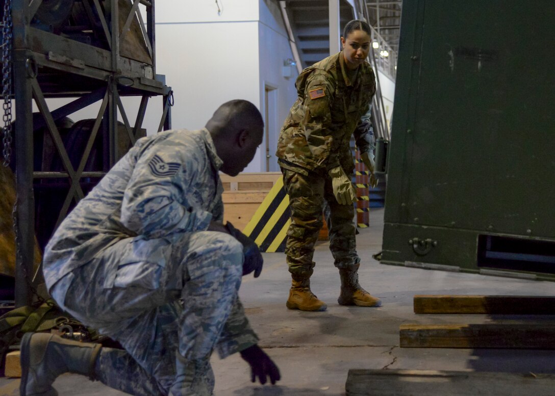 U.S. Air Force Tech. Sgt. Jeremy Roberts, 733rd Logistic Readiness Squadron, readiness spares package NCO in charge, shows U.S. Army Spc. Jena Garcia, 119th Inland Cargo Transfer Company, 11th Transportation Battalion, 7th Transportation Brigade (Expeditionary), motor pool clerk, how to lay a support platform for a supply pod at Joint Base Langley- Eustis, March 2, 2017. Garcia and other Soldiers spent a week training with 733rd LRS Airmen to learn how the Air Force manages its logistics procedures. (U.S. Air Force photo by 1st Lt. Mahalia Frost)