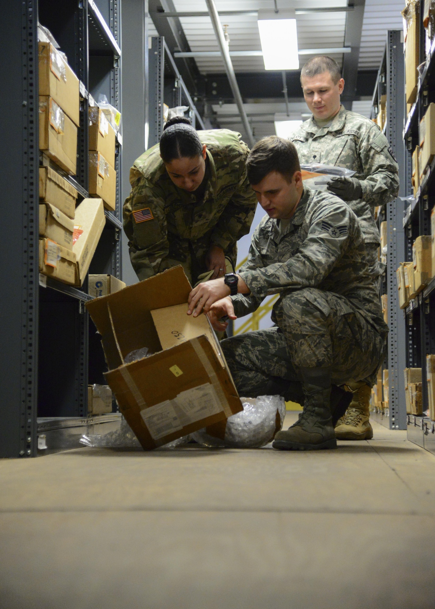 Two U.S. Army Soldiers train with a U.S. Air Force Airmen to learn how the 733rd LRS organizes its supply warehouse during a week-long training at Joint Base Langley-Eustis, Va., March 2, 2017. During the training, service members discussed how Airmen store and keep inventory of individual protective equipment and how the processes of storing hazardous material differs from storing other materials. (U.S. Air Force photo by 1st Lt. Mahalia Frost)