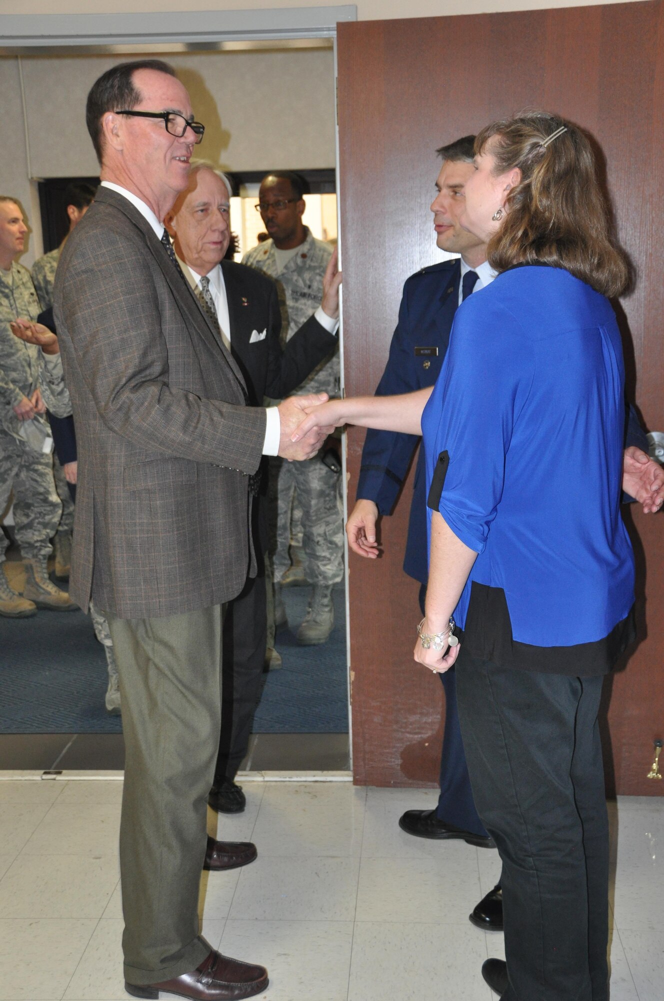 Joe Green, staff member of the Montgomery Chamber of Commerce, shakes hands with Lora Ostrat, while Tom Albrecht, Montgomery civic leader chats with newly minted commander of the 908th Airlift Wing, Col. Ken Ostrat. Green and Albrecht congratulated the Ostrats following his Assumption of Command ceremony March 5 at Maxwell Air Force Base. (U.S. Air Force photo by Bradley J. Clark)