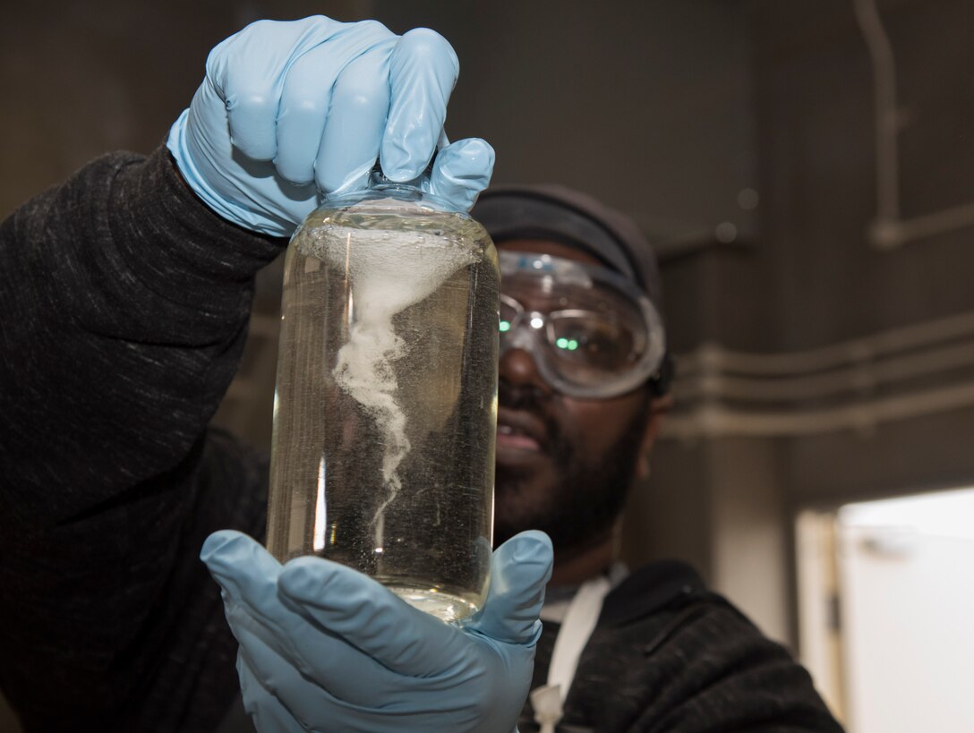 Troy Farris, a fuels laboratory lead technician with the 35th Logistics Readiness Squadron, swirls a bottle of Jet Propellant 8 fuel at Misawa Air Base, Japan, March 6, 2017. When swirled, the fuel will separate any particulate matter from the fuel and float to the bottom of the cyclone. (U.S. Air Force photo by Airman 1st Class Sadie Colbert)