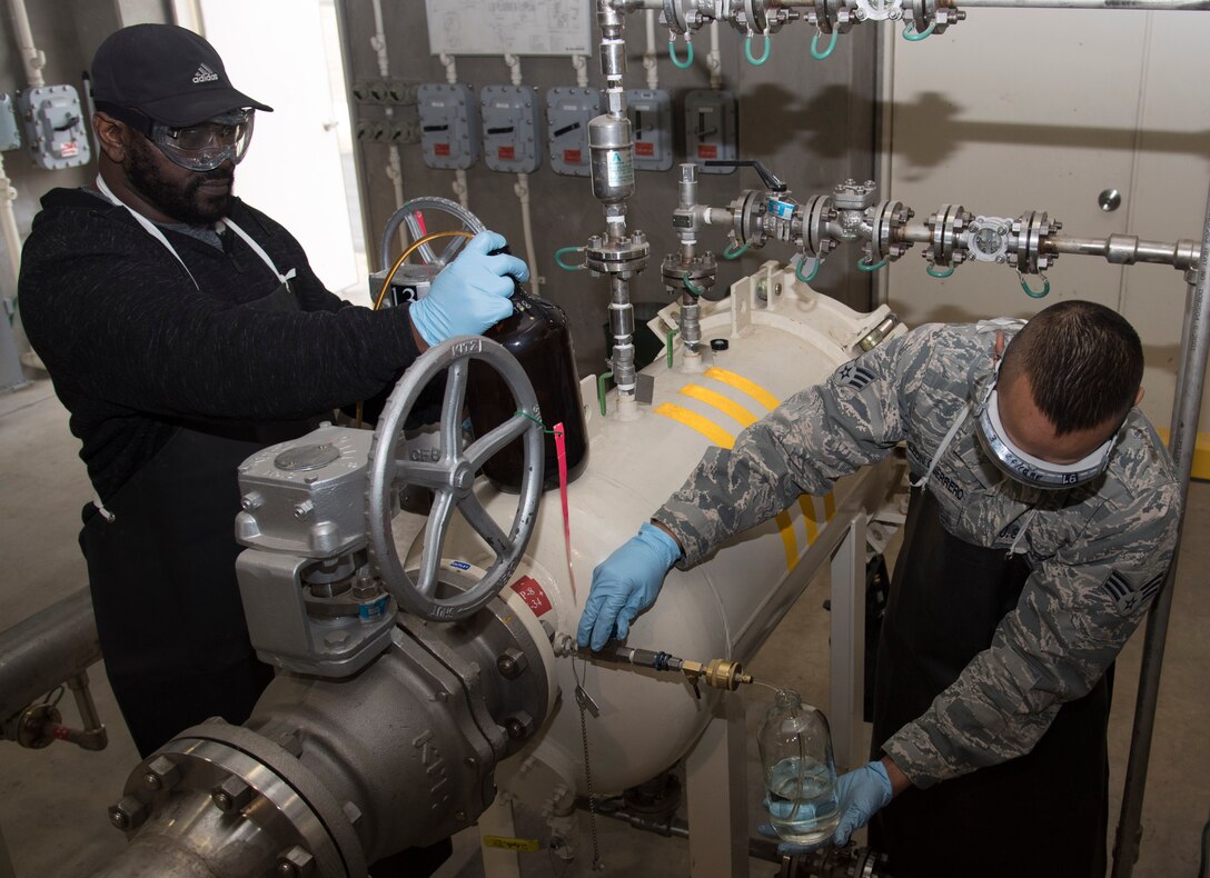 Troy Farris, left, a fuels laboratory lead technician with the 35th Logistics Readiness Squadron, and U.S. Air Force Senior Airman Ken Leon Guerrero, right, a fuels laboratory technician with the 35th LRS, draw Jet Propellant 8 at Misawa Air Base, Japan, March 6, 2017. The fuel is checked for particulate matter, which consist of dirt, grime and water levels in the fuel that could negatively affect the F-16 Fighting Falcon flying mission. (U.S. Air Force photo by Airman 1st Class Sadie Colbert)