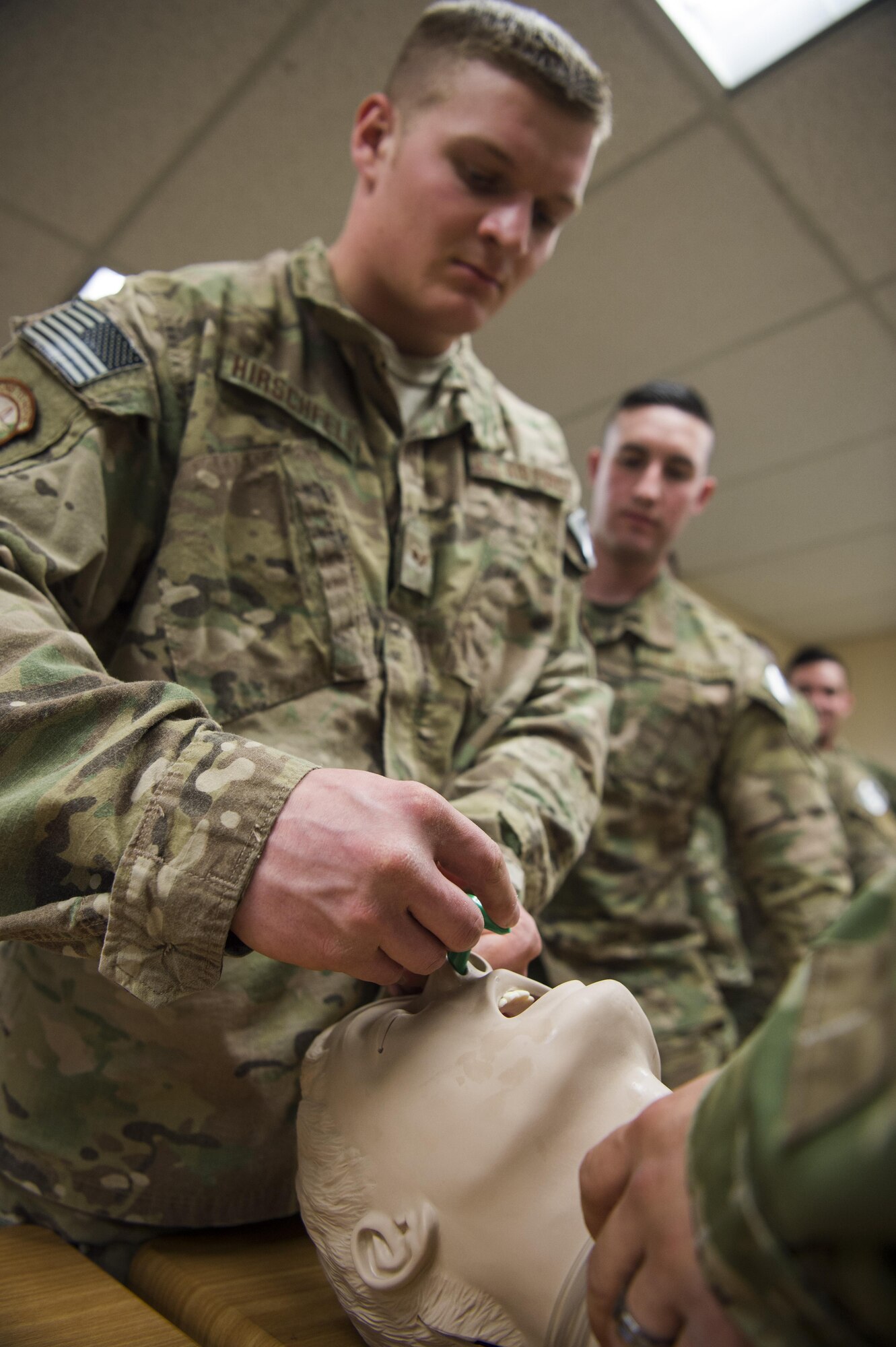 Senior Airman Donovan Hirschfeld, 790th Missile Security Forces Squadron tactical response force assaulter, applies a nasopharyngeal tube to a test head during a Trauma Casualty Care Course on F.E. Warren Air Force Base, Wyo., March 3, 2017. Lifesaving skills such as dressing wounds, applying splints, using combat gauze, proper use of tourniquets, nasopharyngeal airway training and body drag and carries were taught during the course. The Defense Medical Readiness Training Institute hosted the course. DMTRI is a tri-service organization that offers both resident and non-resident joint medical readiness training courses across the military. (U.S. Air Force photo by Staff Sgt. Christopher Ruano)