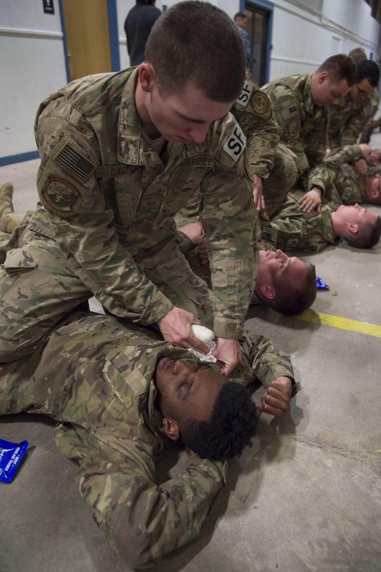 Staff Sgt. Aaron Davis, 790th Missile Security Forces Squadron member, applies combat gauze to Airman 1st Class Daquan Zackery, 790th Missile Security Forces Squadron member during a Trauma Casualty Care Course on F.E. Warren Air Force Base, Wyo., March 3, 2017. Members in the course had to display proper use of all the lifesaving skills taught and score 70 percent or above to pass the course. The Defense Medical Readiness Training Institute hosted the course. DMTRI is a tri-service organization that offers both resident and non-resident joint medical readiness training courses across the military. (U.S. Air Force photo by Staff Sgt. Christopher Ruano)