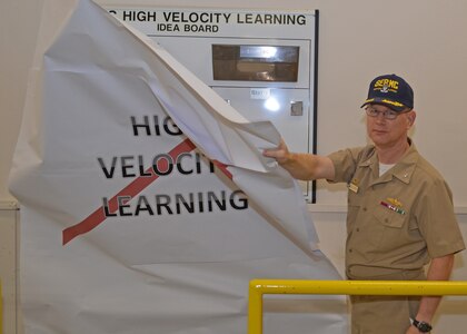 Capt. Dave Gombas, Commanding Officer at Southeast Regional Maintenance Center (SERMC) removes paper to reveal one of 10 “idea boards” placed throughout the command. The boards are engineered to promote creative problem solving from deckplate Sailors and Civilian employees. High Velocity organizations solve problems as they arise, and develop mechanisms to prevent them from recurring.