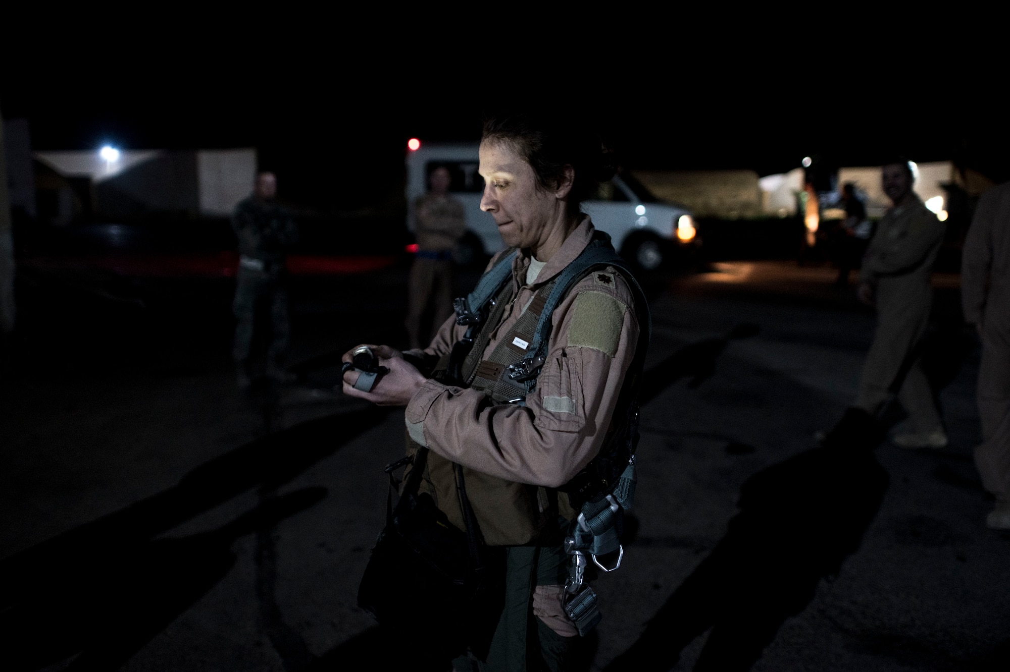 Maj. Staci Landers, 389th Expeditionary Fighter Squadron executive officer, uses a flashlight after her fini flight Feb. 27, 2017 in Southwest Asia. Landers and her husband were recently deployed together and performed duties supporting the fight against ISIS. (U.S. Air Force photo by Staff Sgt. Eboni Reams)