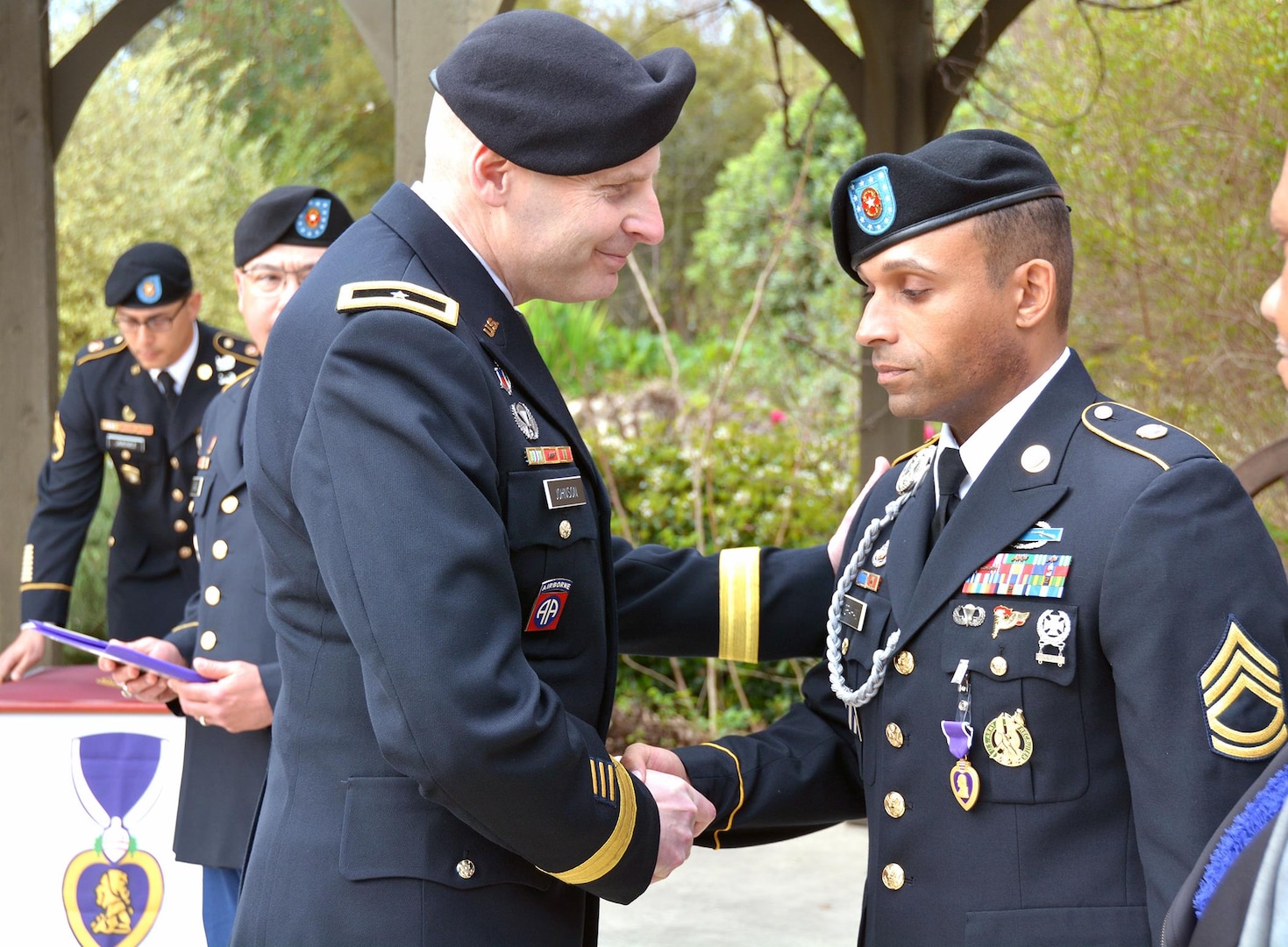 Brig. Gen.  Jeffrey Johnson (left), Brooke Army Medical Center commanding general, presents the Purple Heart medal to Sgt. 1st Class Charles Graham (right) during a ceremony at the Warrior and Family Support Center March 3. Graham was wounded Nov. 9, 2005, when his unit was struck by indirect fire mortar rounds while at a Forward Operating Base in Iraq. 