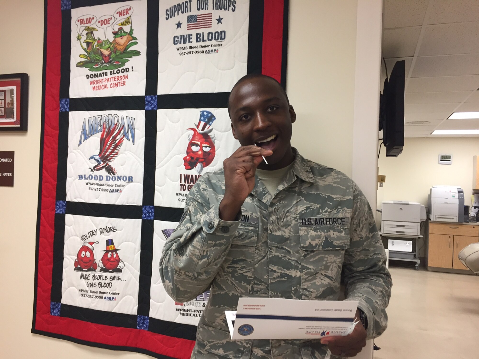 Senior Airman Floyd Ferguson Jr., senior technician at the Blood Donor Center at the Wright-Patterson Medical Center, demonstrates how easy it is to join the national bone marrow donor registry by taking a buccal (cheek cell) swab. A blood and bone marrow double donor drive is scheduled for March 13 from 8 a.m. to 4 p.m. in the second-floor center. (Skywrighter photo/Amy Rollins)
