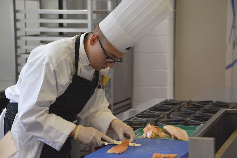 Marine Corps Staff Sgt. Joseph Hale removes the skin from a fillet of rainbow trout during the Armed Forces Chef of the Year portion of the 42nd annual Military Culinary Arts Competitive Training Event at Fort Lee, Va., March 3, 2017. Army photo by Amy Perry
