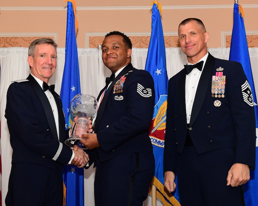 Gen. Hawk Carlisle, left, commander, Air Combat Command presents an award to Tech. Sgt. Jose Cruz-Richardson, 15th Air Support Operations Squadron chief of weapons and tactics, Fort Stewart, Georgia, as Chief Master Sgt. Steve McDonald, command chief, ACC observes during the 2017 Outstanding Airmen of the Year banquet at the Bayview Community Center at Langley AFB, Virginia, March 8, 2017. The 12 Outstanding Airmen earn the Outstanding Airman ribbon with the bronze service star device and wear the Outstanding Airman badge for one year. They also serve on the Air Force Enlisted Council for one year. (U.S. Air Force photo by Staff Sgt. Nick Wilson)