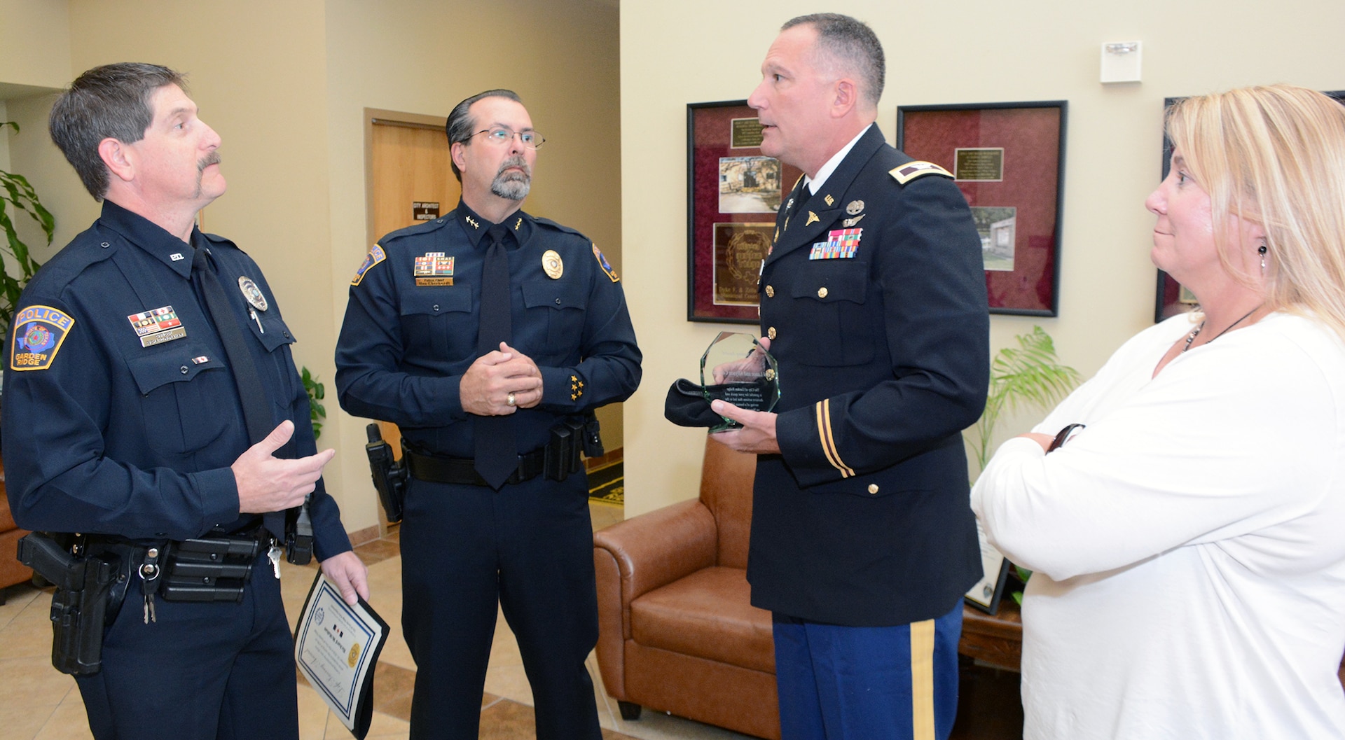 Col. (Dr.) Lance Cordoni holds the award he received March 1 while talking with City of Garden Ridge police officer Richard McMahan (left), Police Chief Ron Eberhardt, and his wife, Allyson Cordoni. Cordoni helped save the life of a neighbor who had suffered a heart attack Nov. 20, 2016.