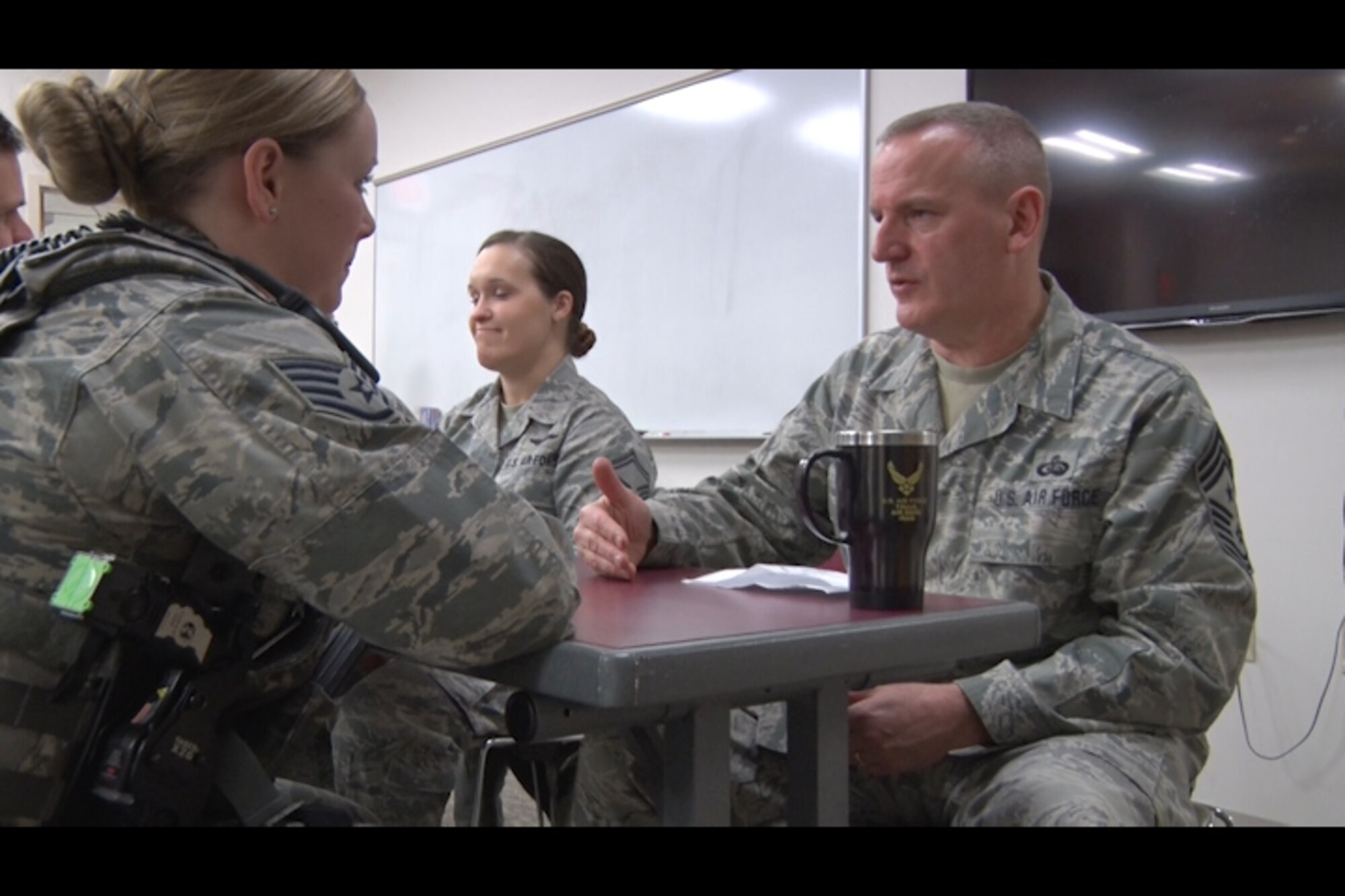 Staff Sgt. Kelsey Hannafin, 157th Security Forces Squadron member, talks with Chief Master Sgt. James Lawrence, 157th Air Refueling Wing Command Chief Master Sergeant, during the speed- mentoring event at Pease Air National Guard Base, N.H. Feb. 5. The event was created as an opportunity for NCOs to build professional relationships and aid their military career. (N.H. Air National Guard still from video by Tech. Sgt. Erica Rowe)