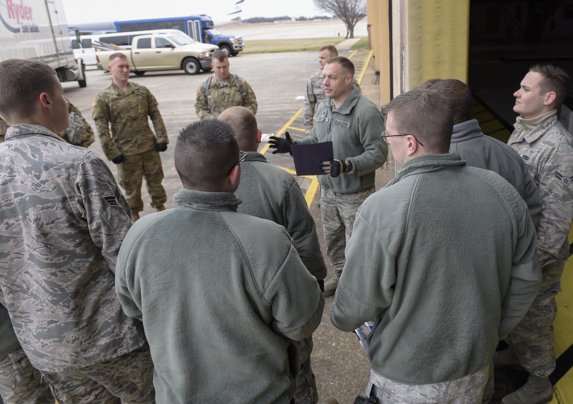 The Joint Records Team (JRT) operations officer U.S. Air Force Capt. Nathan Tilton briefs JRT members prior to receiving presidential materials at a hangar on Joint Base Andrews, Md., Feb 14, 2017. JRT members included Airmen assigned to the Air Force District of Washington (AFDW) and Soldiers from the U.S. Army's 3rd Infantry Division "The Old Guard" worked in concert with Presidential Material Handlers from the National Archives and Records Management (NARA) over several months to ensure the safe movement of the records and artifacts gathered during the eight years of President Obama's administration. The JRT was tasked with helping to inventory, prepare for shipping, palletize and load several tons of paper records, terabytes of electronic records, and thousands of artifacts. Along with several truck shipments the bulk of the materials were loaded onto and Air Force C-5 Galaxy cargo aircraft brought in from Dover Air Force Base, Del., and were then flown to Chicago, Ill., where they were placed in secure storage until completion of Obama's Presidential Library. The library is part of the presidential library system, which is administered by the National Archives and Records Administration. (U.S. Air Force photo/Jim Varhegyi) (released)