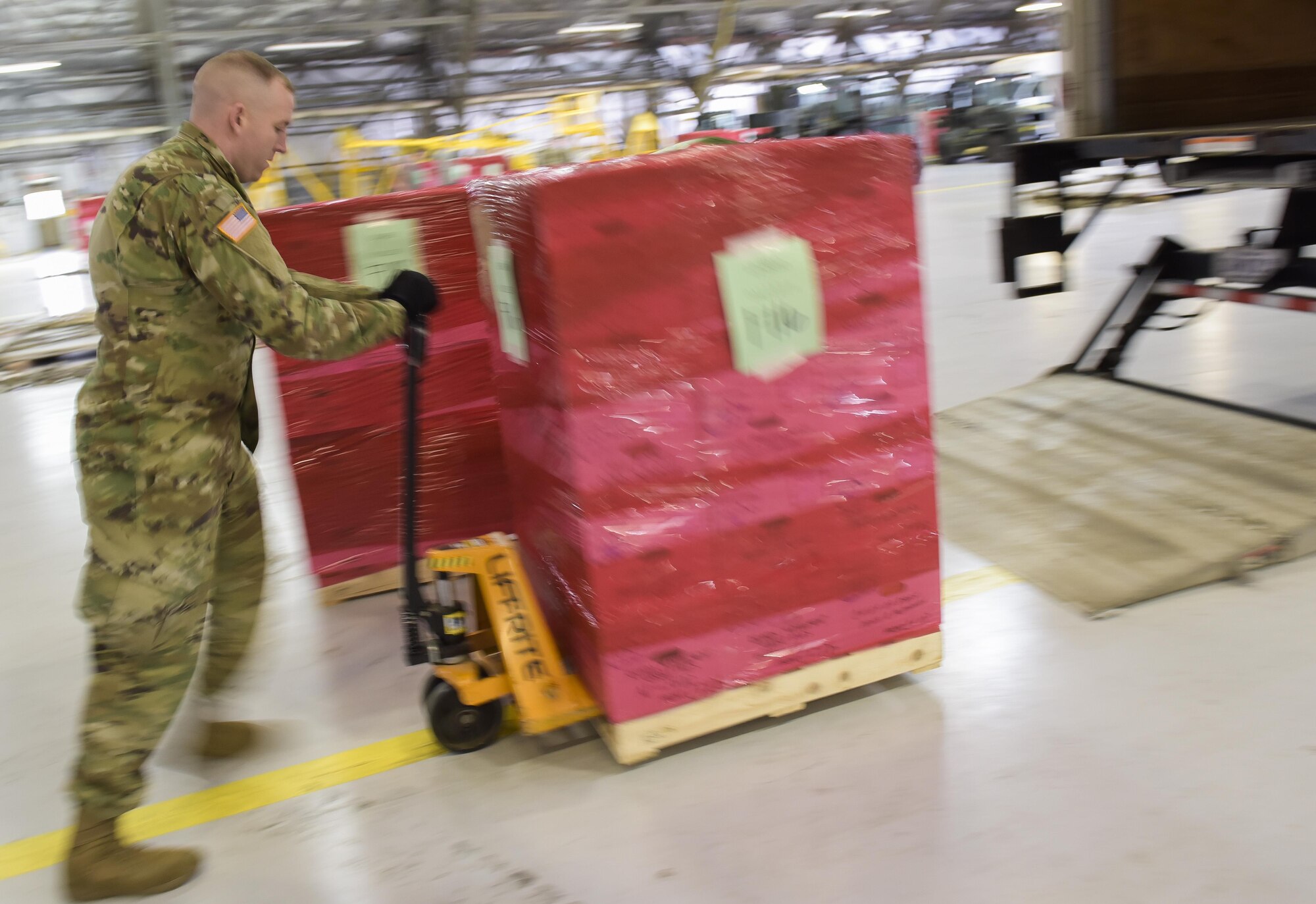 The Joint Records Team (JRT) officer in charge (OIC) of team DC, U.S. Army Capt. Scott McInernie, moves a pallet full of presidential records in a hangar on Joint Base Andrews, Md., Feb 14, 2017. The JRT was made up of Airmen assigned to the Air Force District of Washington (AFDW) and Soldiers from the U.S. Army's 3rd Infantry Division "The Old Guard" worked in concert with Presidential Material Handlers from the National Archives and Records Management (NARA) over several months to ensure the safe movement of the records and artifacts gathered during the eight years of President Obama's administration. The JRT was tasked with helping to inventory, prepare for shipping, palletize and load several tons of paper records, terabytes of electronic records, and thousands of artifacts. Along with several truck shipments the bulk of the materials were loaded onto and Air Force C-5 Galaxy cargo aircraft brought in from Dover Air Force Base, Del., and were then flown to Chicago, Ill., where they were placed in secure storage until completion of Obama's Presidential Library. The library is part of the presidential library system, which is administered by the National Archives and Records Administration. (U.S. Air Force photo/Jim Varhegyi) (released)