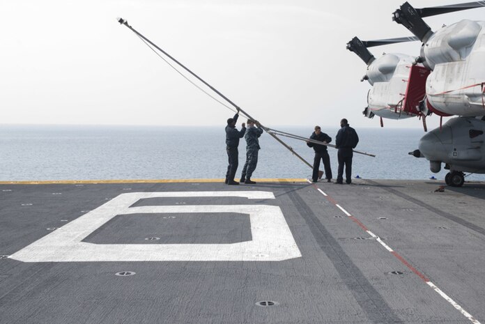Sailors lower the jack staff on the flight deck of amphibious assault ship USS Bonhomme Richard (LHD 6) as the ship departs White Beach Naval Facility, Mar. 8, 2017. The jack staff is used for hoisting the Navy's First Jack Flag flown while the ship is moored in port. Bonhomme Richard, flagship of the Bonhomme Richard Expeditionary Strike Group, with embarked 31st Marine Expeditionary Unit, is on a routine patrol, operating in the Indo-Asia-Pacific region to enhance warfighting readiness and posture forward as a ready-response force for any type of contingency.