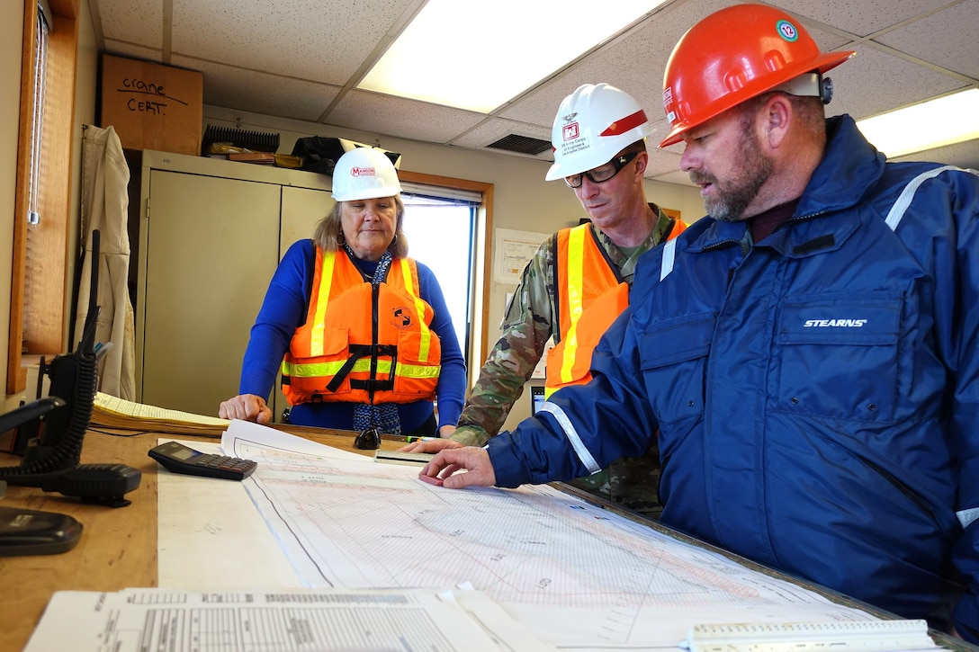 A Seattle-based Manson Construction employee shows Channel Islands Harbor Director Lyn Krieger and Los Angeles District Commander Col. Kirk Gibbs the hydrographic survey map of the area the hydraulic cutter-head suction dredge H.R. Morris will dredge Feb. 14. Manson, the Corps' contractor for the project, piped the dredged material to nearby Hueneme Beach to replenish sand lost to erosion.