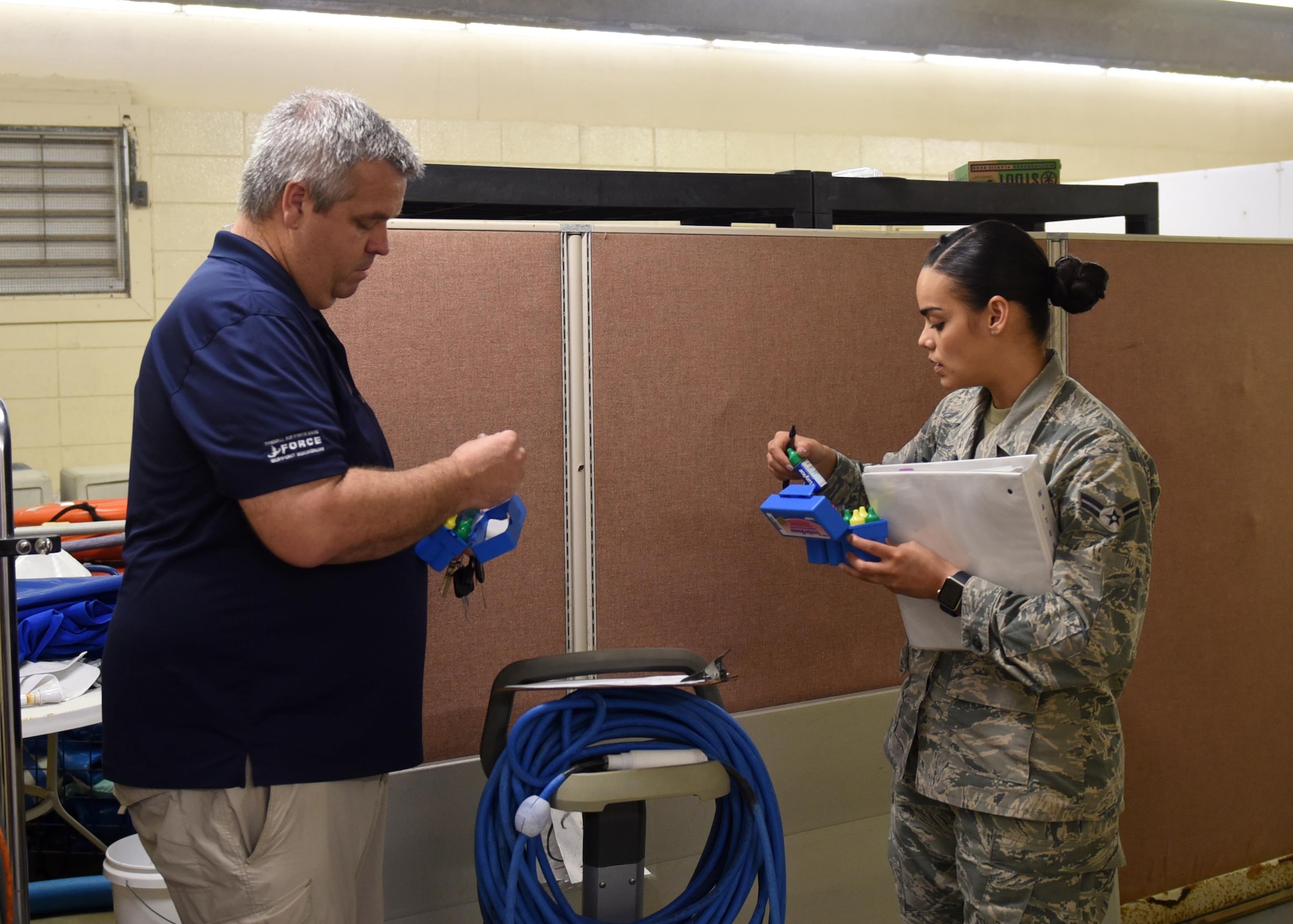 Richard Clampitt, Bonita Bay outdoor recreation assistant manager, and Airman 1st Class Dannyel Butte, 325th Aerospace Medicine Squadron bioenvironmental engineering apprentice, examine pool water test kits at Tyndall Air Force Base, Fla., Feb. 23, 2017. The pool and facility must undergo several revitalization processes prior to opening for the upcoming season. (U.S. Air Force photo by Airman 1st Class Isaiah J. Soliz/Released)