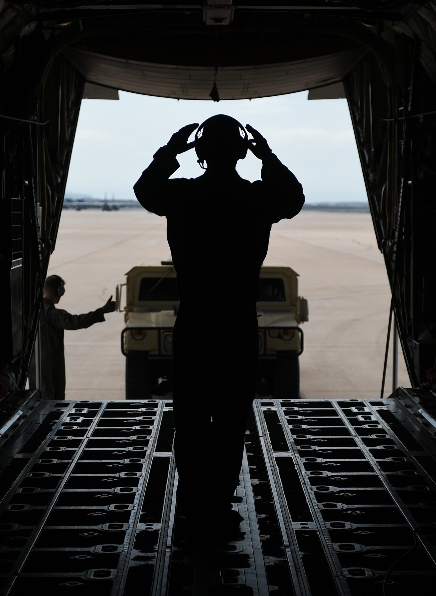 U.S. Air Force Senior Airman John Soto marshals a convoy vehicle and trailer into the cargo area of a C-130J Super Hercules March 8, 2017, at Dyess Air Force Base, Texas. Two of the ten events that make up the 317th Airlift Group Rodeo competition was a reverse taxi and convoy on and off-load which judged both pilots and loadmasters on their ability to successfully complete the tasks. (U.S. Air Force photo by Airman 1st Class Emily Copeland)  