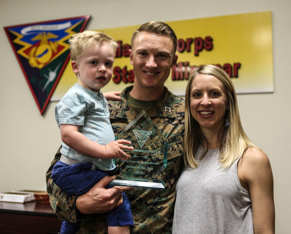 Capt. E. Thomas “Tom” Pinnell III, center, assistant judge advocate with Marine Wing Headquarters Squadron (MWHS) 3, along with his family, displays his Marine Corps Air Station Miramar’s Athlete of the Year trophy, during a ceremony at MCAS Miramar, Calif., March 7. Pinnell competed in the 2017 Conseil International du Sport Militaire (CISM) Military World Cup and received the MCAS Miramar’s Athlete of the Year award twice. (U.S. Marine Corps photo by Cpl. Harley Robinson/Released)
