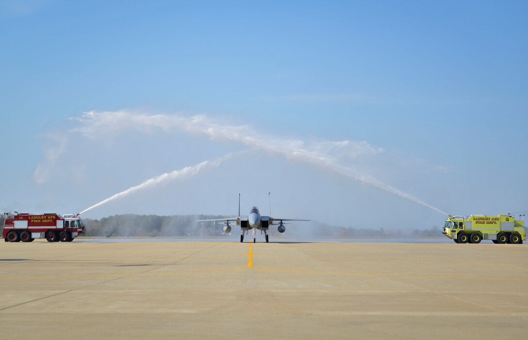 Photo of Gen. Herbert “Hawk” Carlisle, taxing through fire trucks’ streams after his final flight