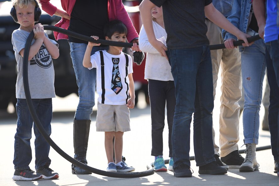 Blaise “Hawk Jr.” Murshid, grandson of U.S. Air Force Gen. Herbert “Hawk” Carlisle’s, commander of Air Combat Command, prepares to hose-down his grandfather after Carlisle’s final flight at Joint Base Langley-Eustis, Va., March 9, 2017. Hosing-down a pilot is a tradition that is a part of the final flight celebration. (U.S. Air Force photo/Staff Sgt. Natasha Stannard)