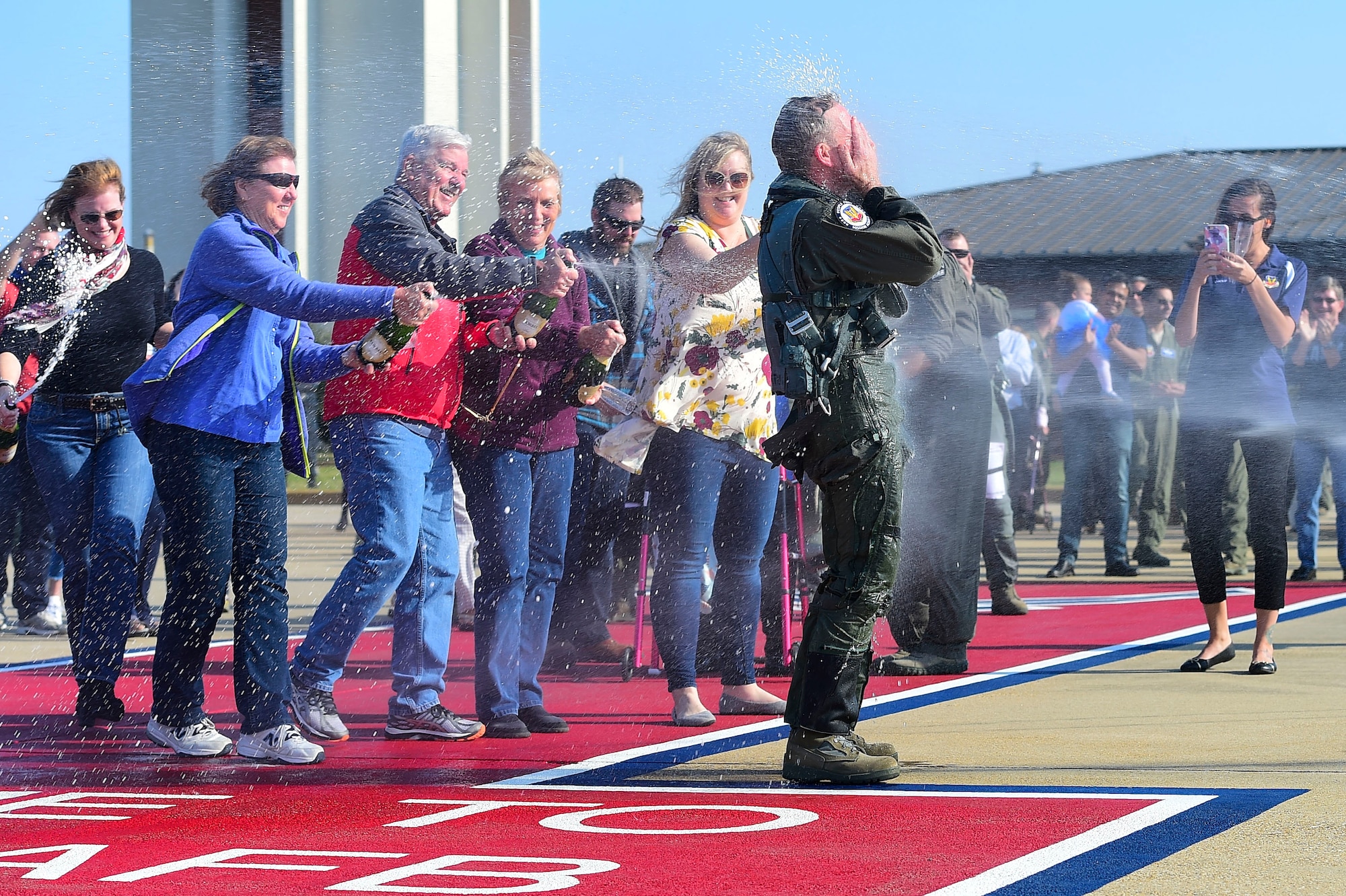 Photo of Gen. Herbert “Hawk” Carlisle, hosed down by his family and friends after taking his final flight