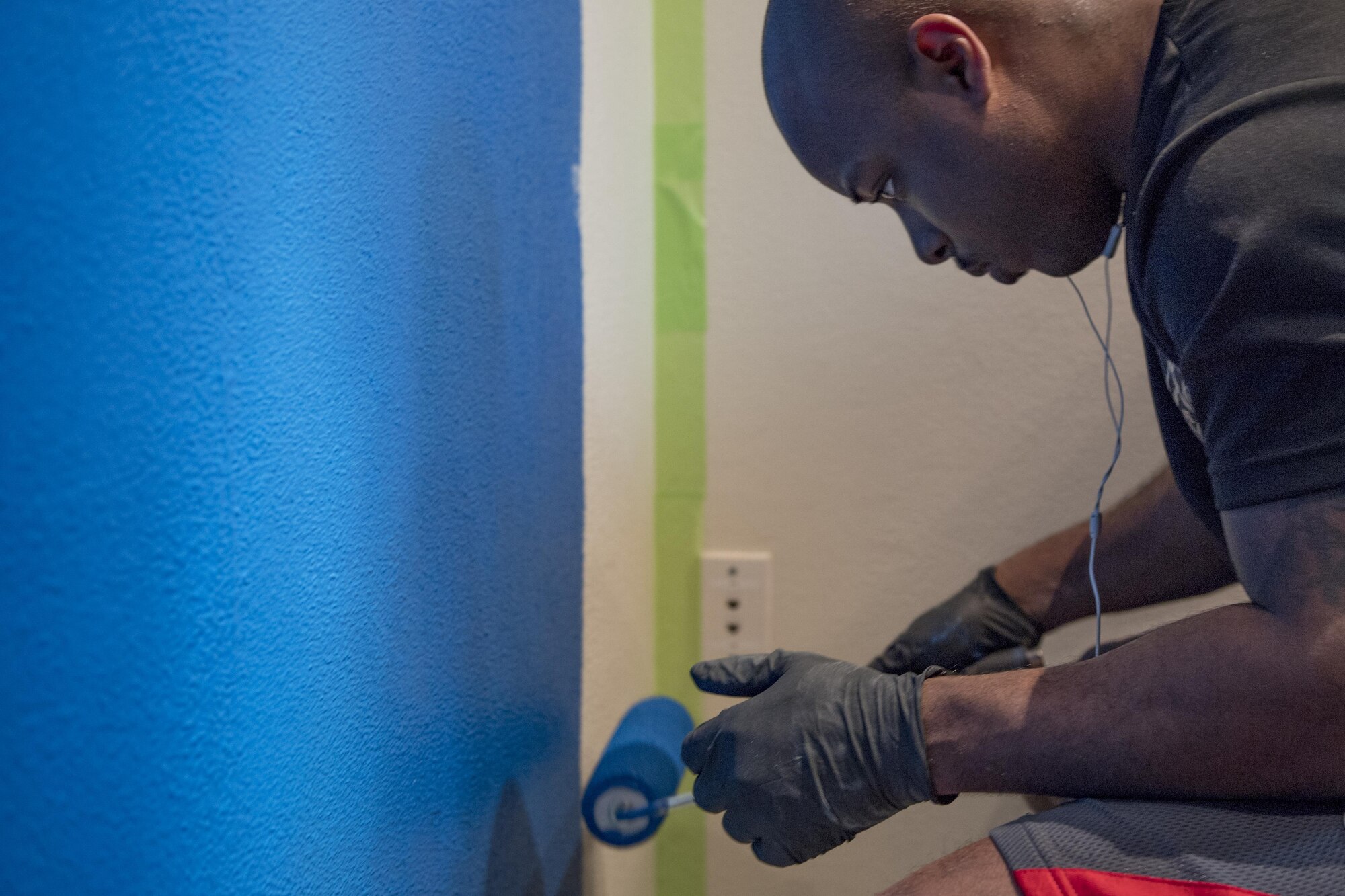 Staff Sgt. Cordero J. Sanderson, 374th Logistics Readiness Squadron’s Petroleum Oil Lubricants flight NCO in charge of the fuels service center, paints a wall at West Elementary School during a volunteer event, March 4, 2017, at Yokota Air Base, Japan. The intent of the new paint was to help brighten the children’s learning environment. (U.S. Air Force photo by Airman 1st Class Donald Hudson)