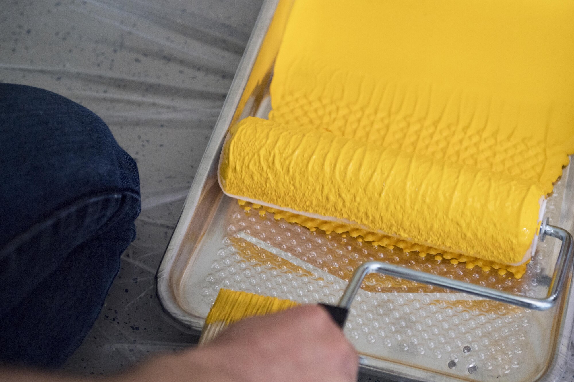 An Airman from the 374th Logistics Readiness Squadron’s Petroleum Oil Lubricants flight, loads yellow paint onto a roller at West Elementary School during a volunteer event on March 4, 2017, at Yokota Air Base, Japan. The volunteers were from Yokota’s 374 LRS and the 374th Contracting Squadron. (U.S. Air Force photo by Airman 1st Class Donald Hudson)