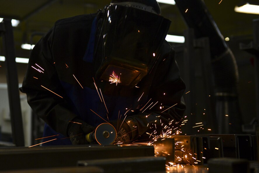 U.S. Air Force Senior Airman Kelly Huddleston, 51st Maintenance Squadron aircraft metals technology journeyman, smooths out a freshly welded piece of metal at Osan Air Base, Republic of Korea, March 7, 2017. Huddleston was fabricating an A-frame for a missile stand from scratch, running through the entire process of cutting, assembling, welding and smoothing the metal into a finished product. (U.S. Air Force photo by Staff Sgt. Victor J. Caputo)