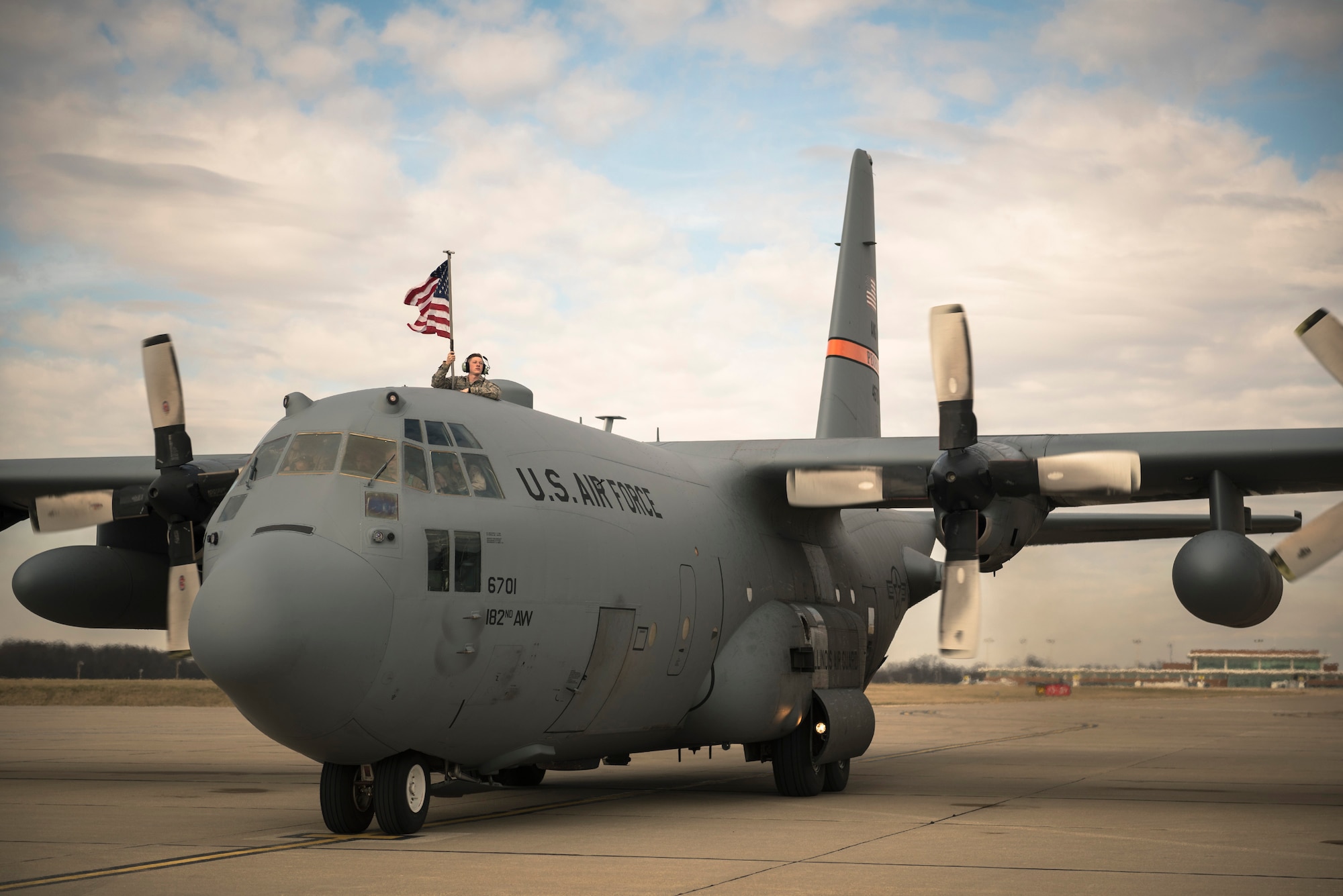 A member of the 182nd Airlift Wing waves the American flag as his C-130 Hercules returns to Peoria, Ill., from an overseas deployment March 5, 2017. More than 100 182nd Airlift Wing Airmen deployed to an undisclosed location in Southwest Asia in support of Operation Freedom’s Sentinel. (U.S. Air National Guard photo by Tech. Sgt. Lealan Buehrer)